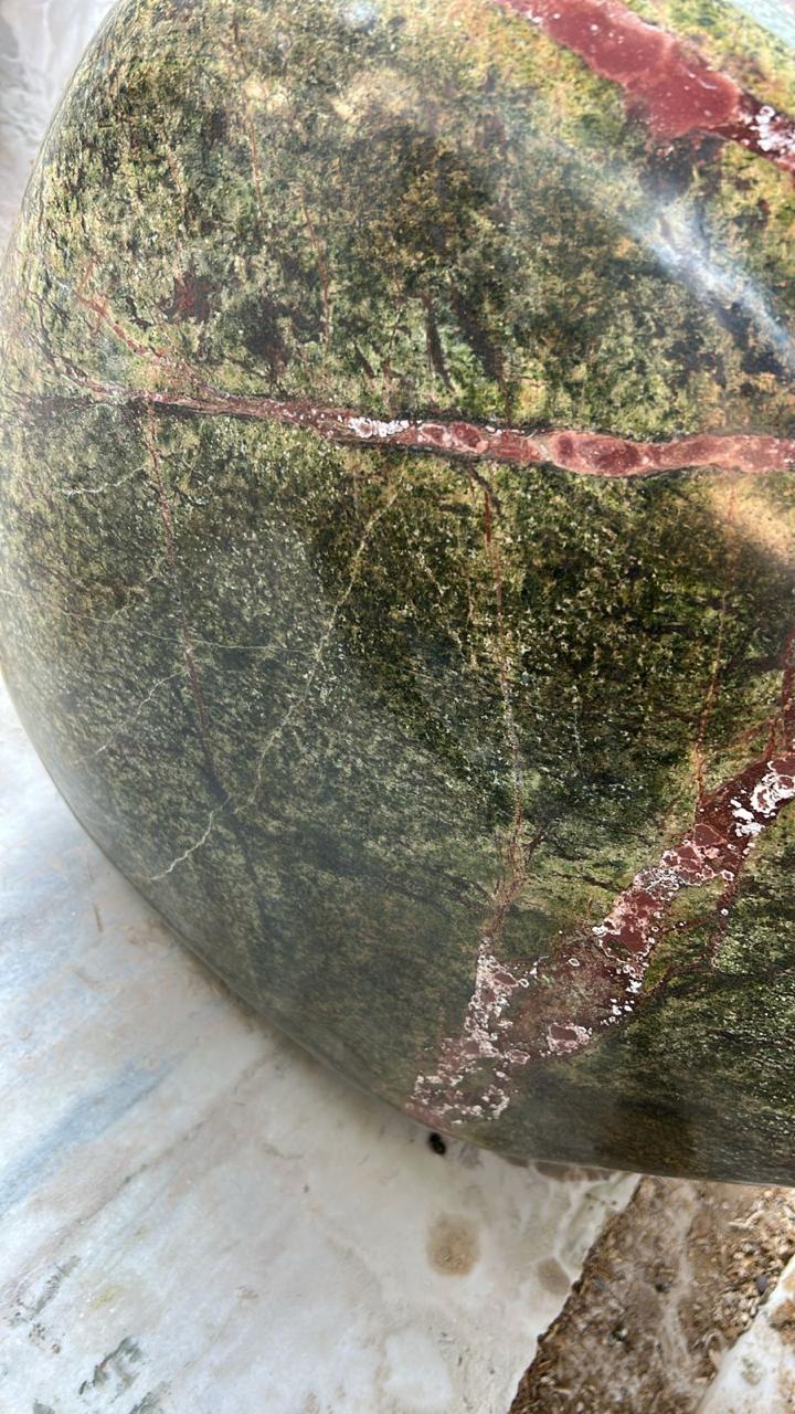 Close-up of green marble with branching rust and cream mineral movement