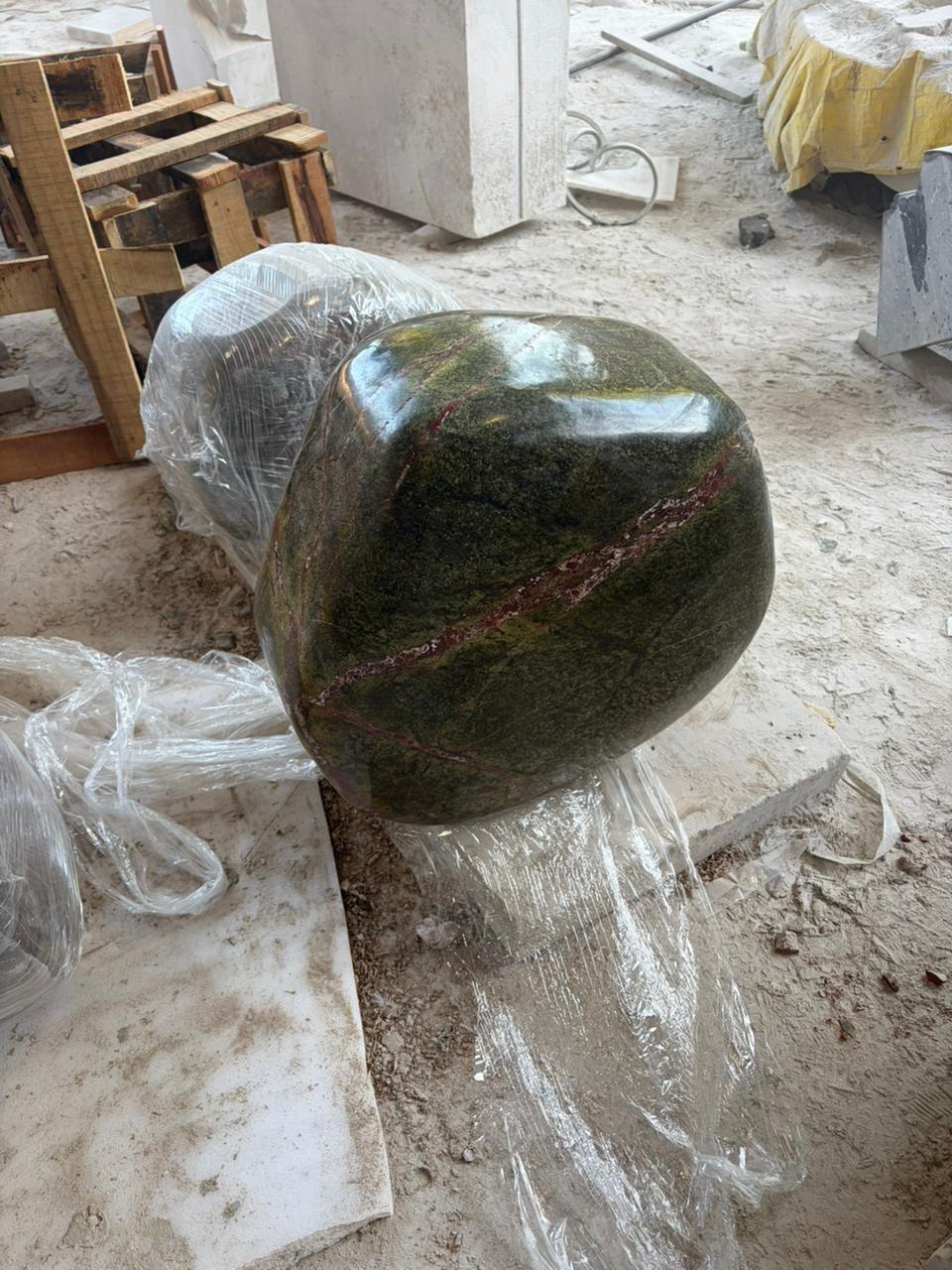 Finished rounded green marble support with rust-coloured veining in the Jaipur workshop