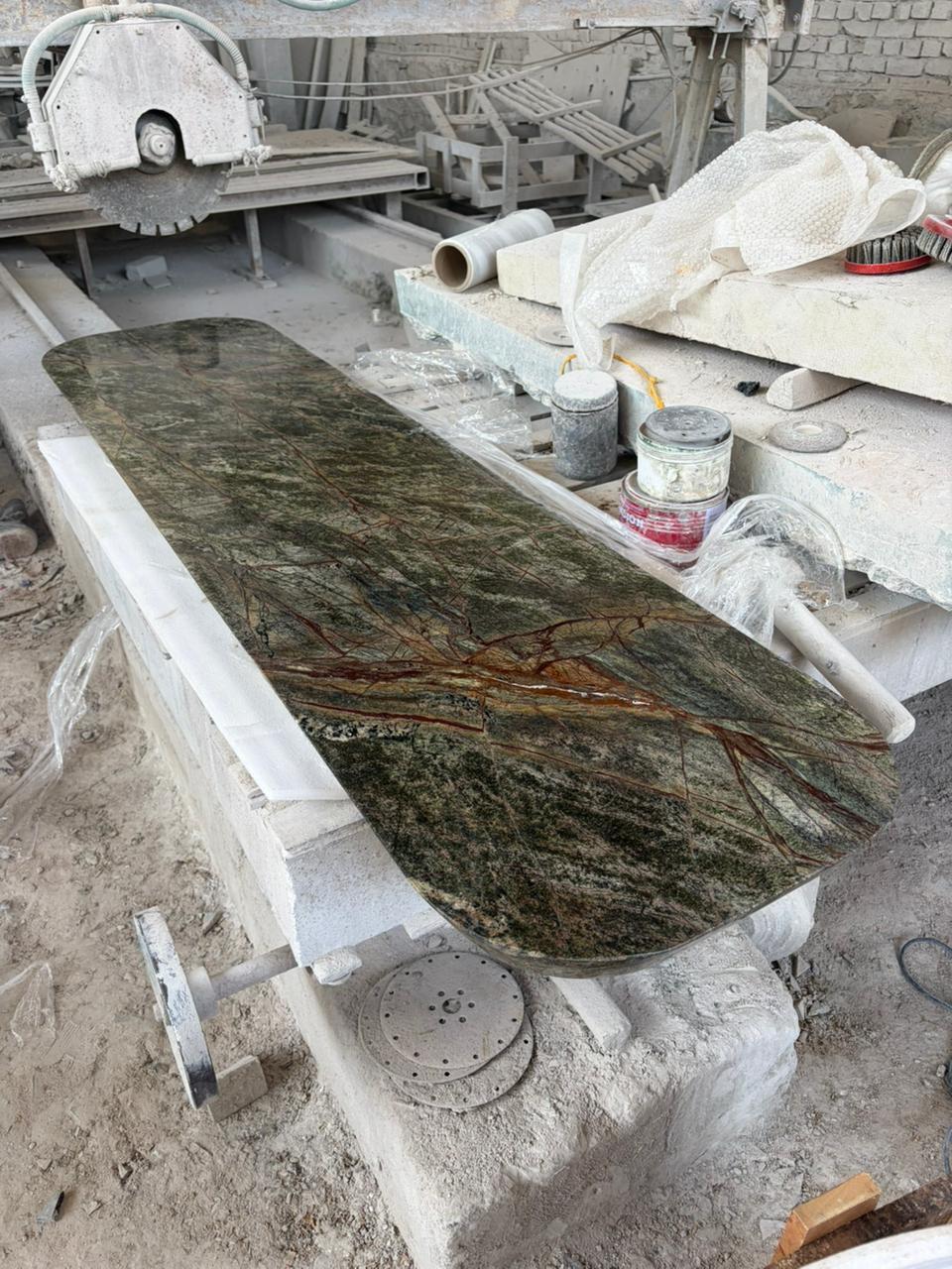 Finished elongated marble tabletop with rounded ends on workshop supports